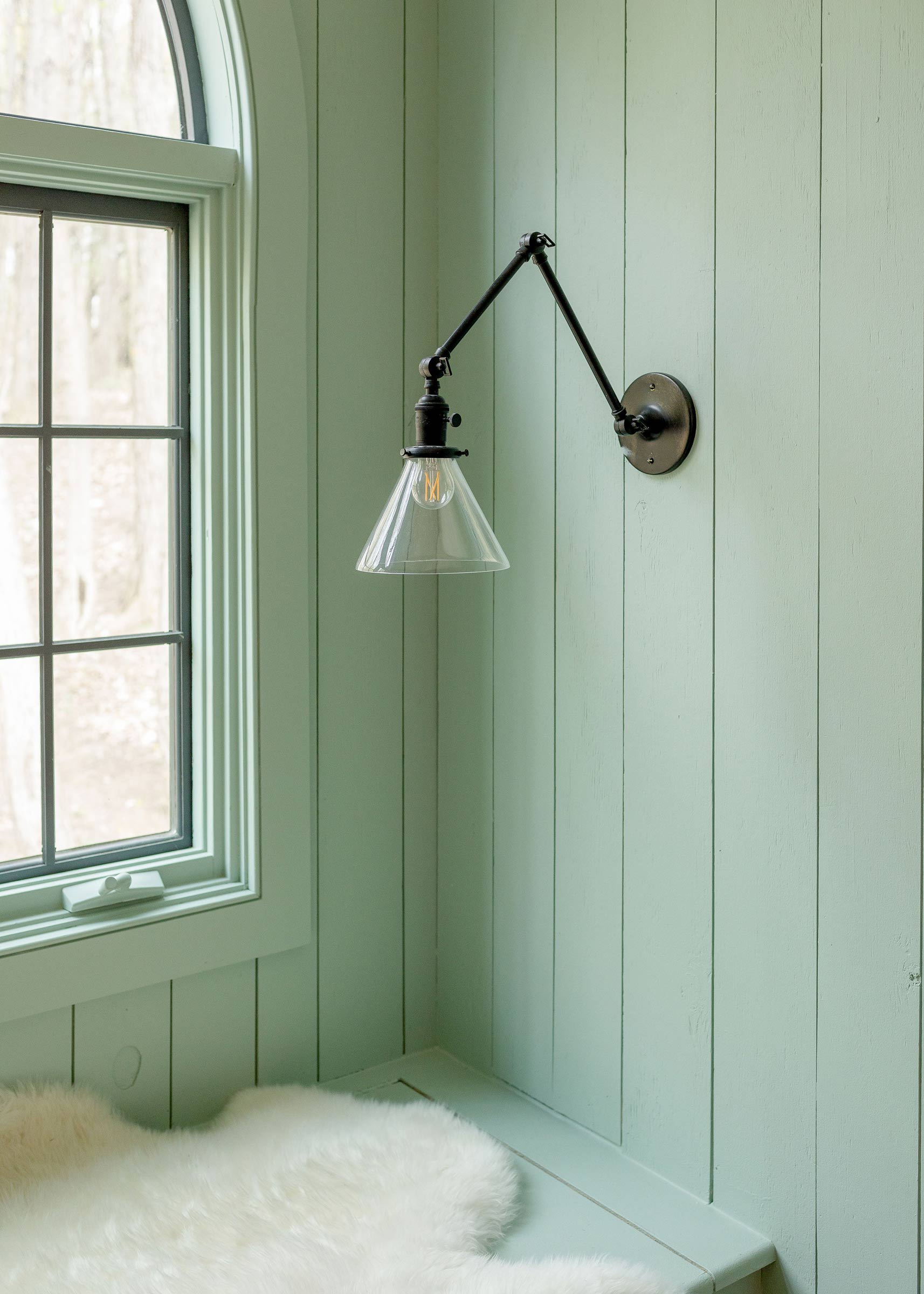 The Princeton Long Arm wall sconce by a window. 