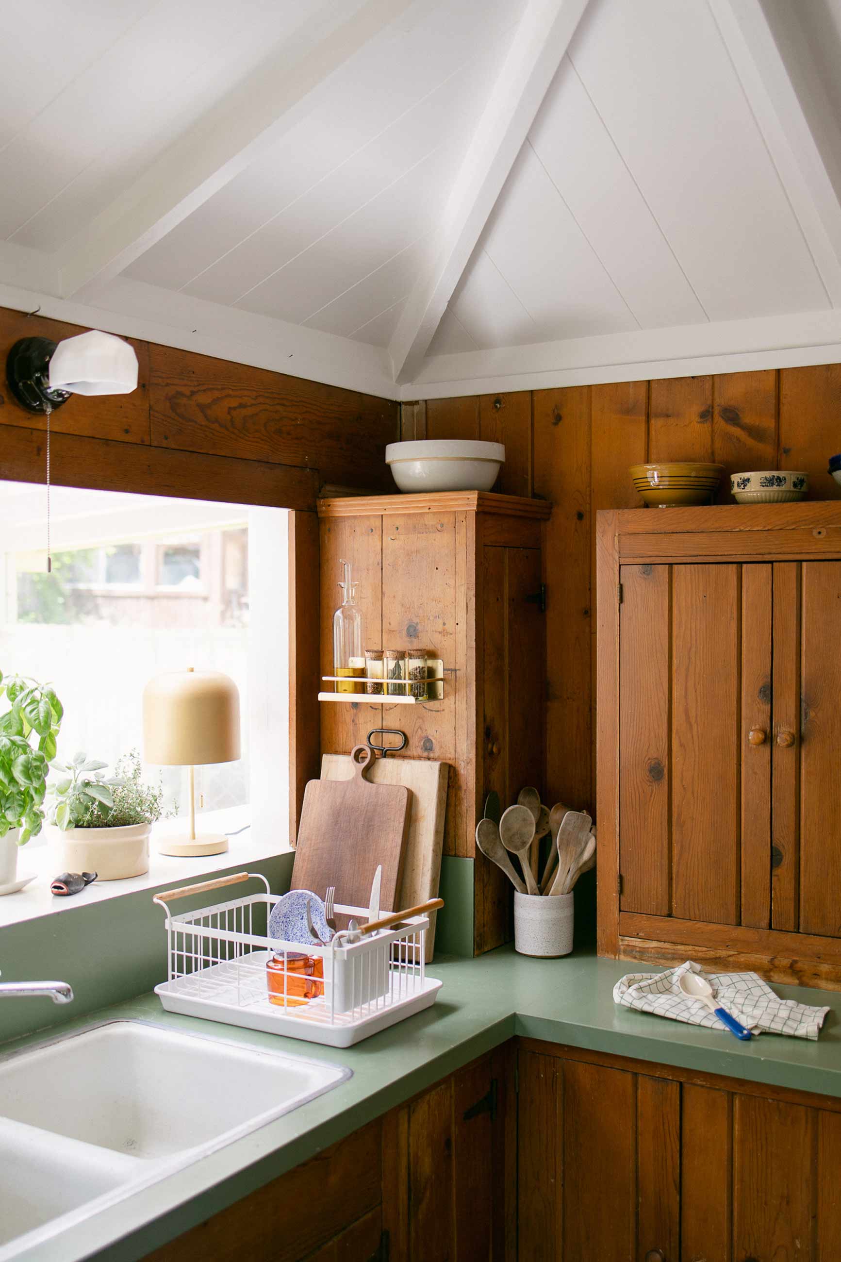 Tidy kitchen with wood cabinets and green countertops. 