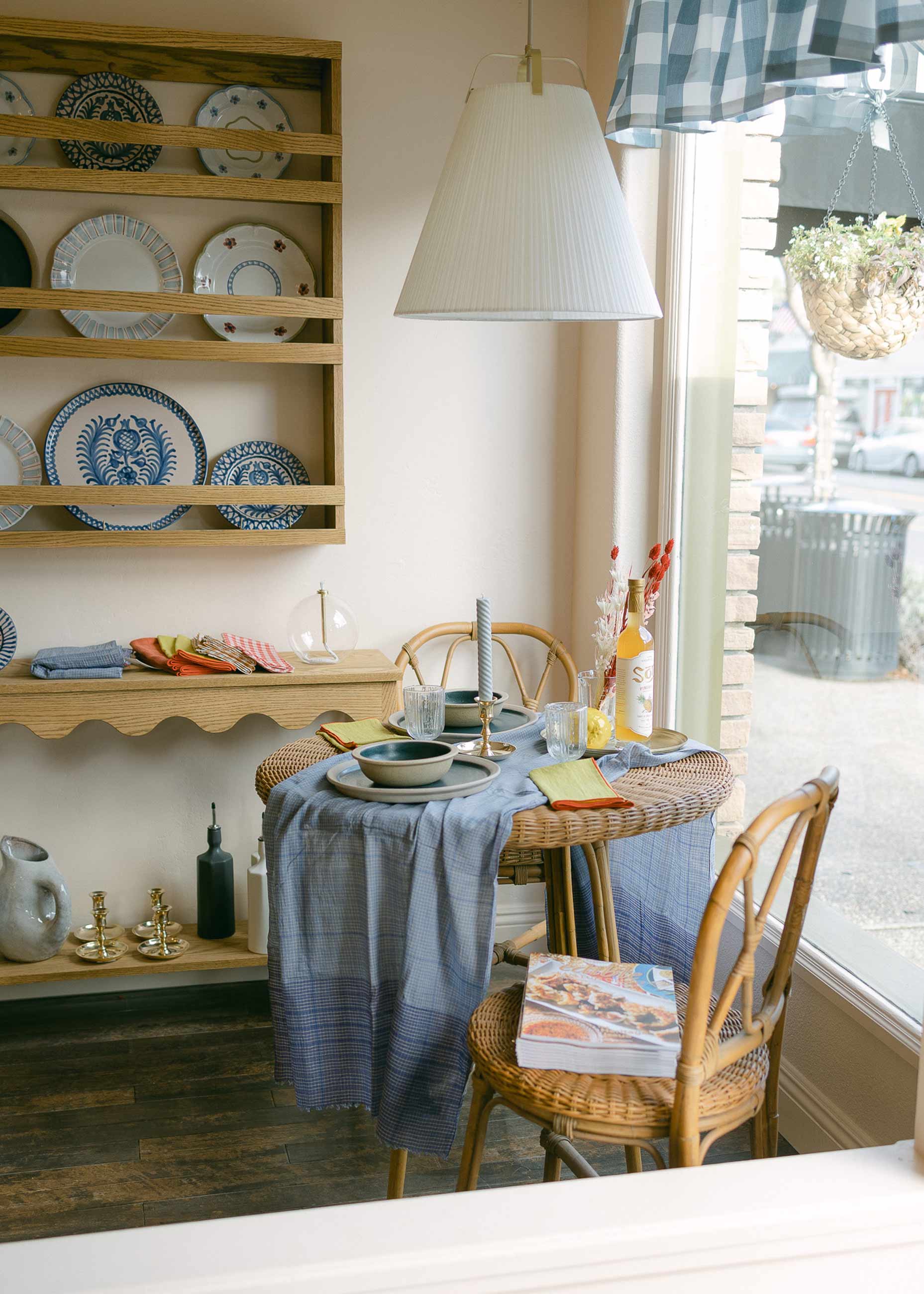 Small table and chairs in window of shop. 