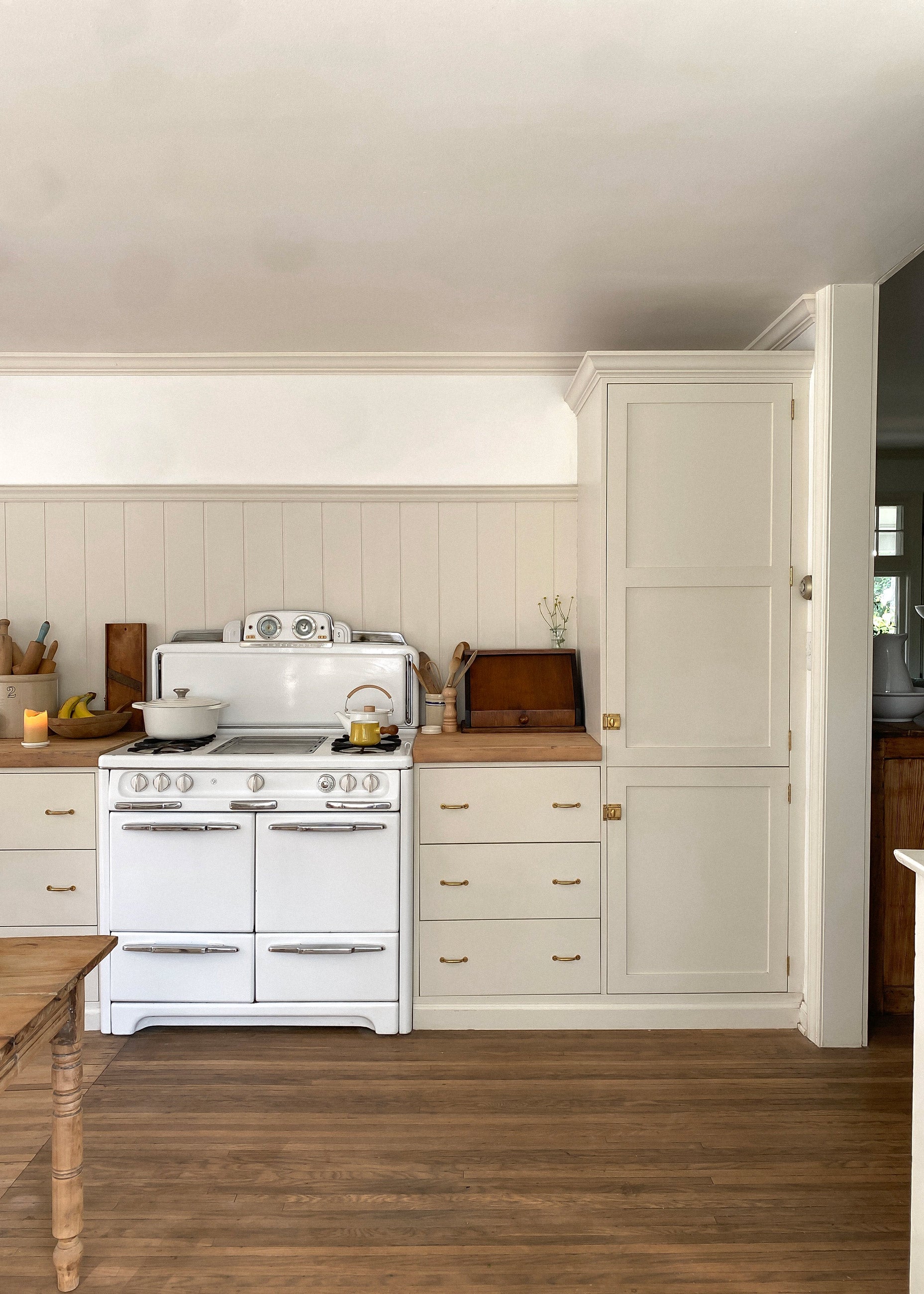 Bright white kitchen in a traditional style home with a vintage stove.