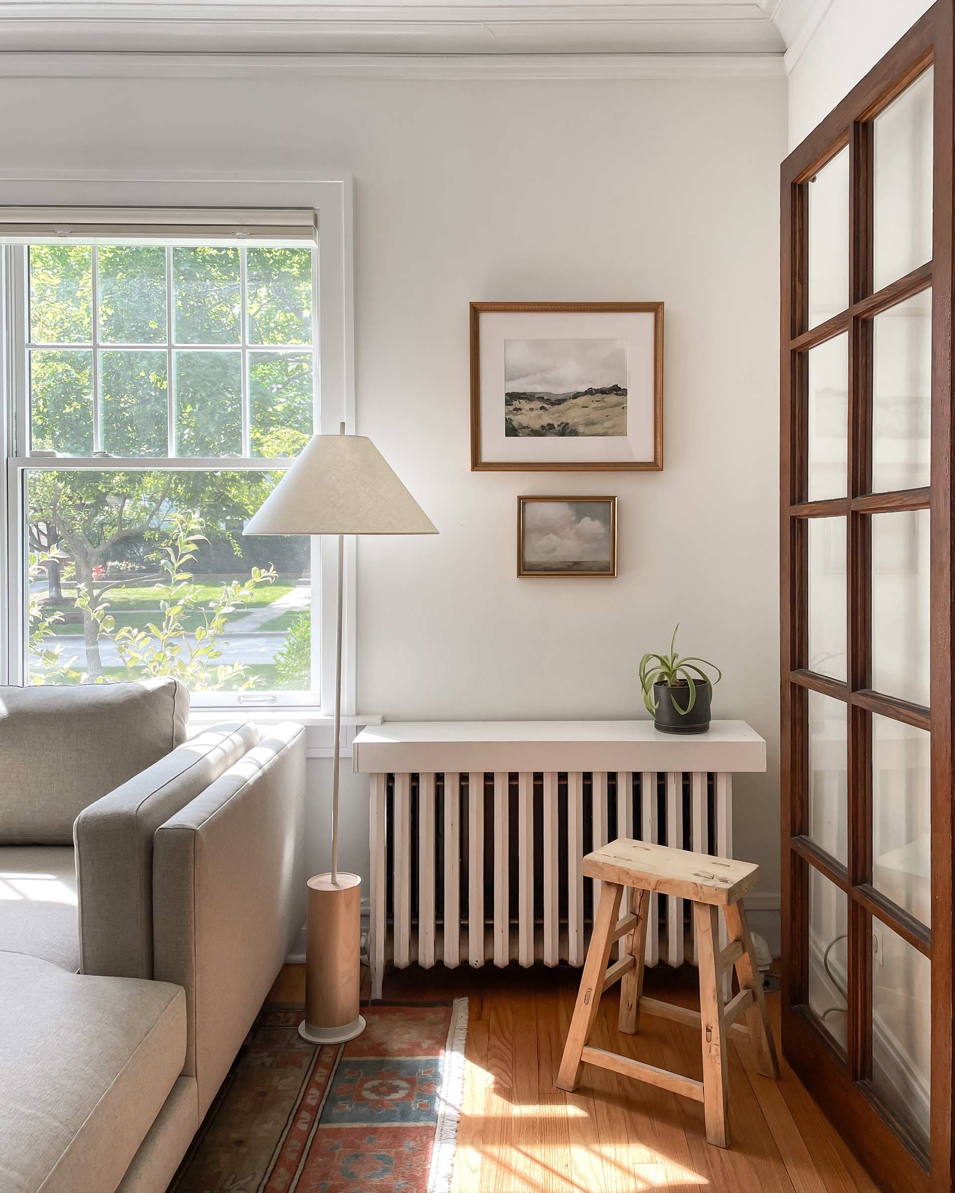 A shaker-style wood base floor lamp in a living room nook.