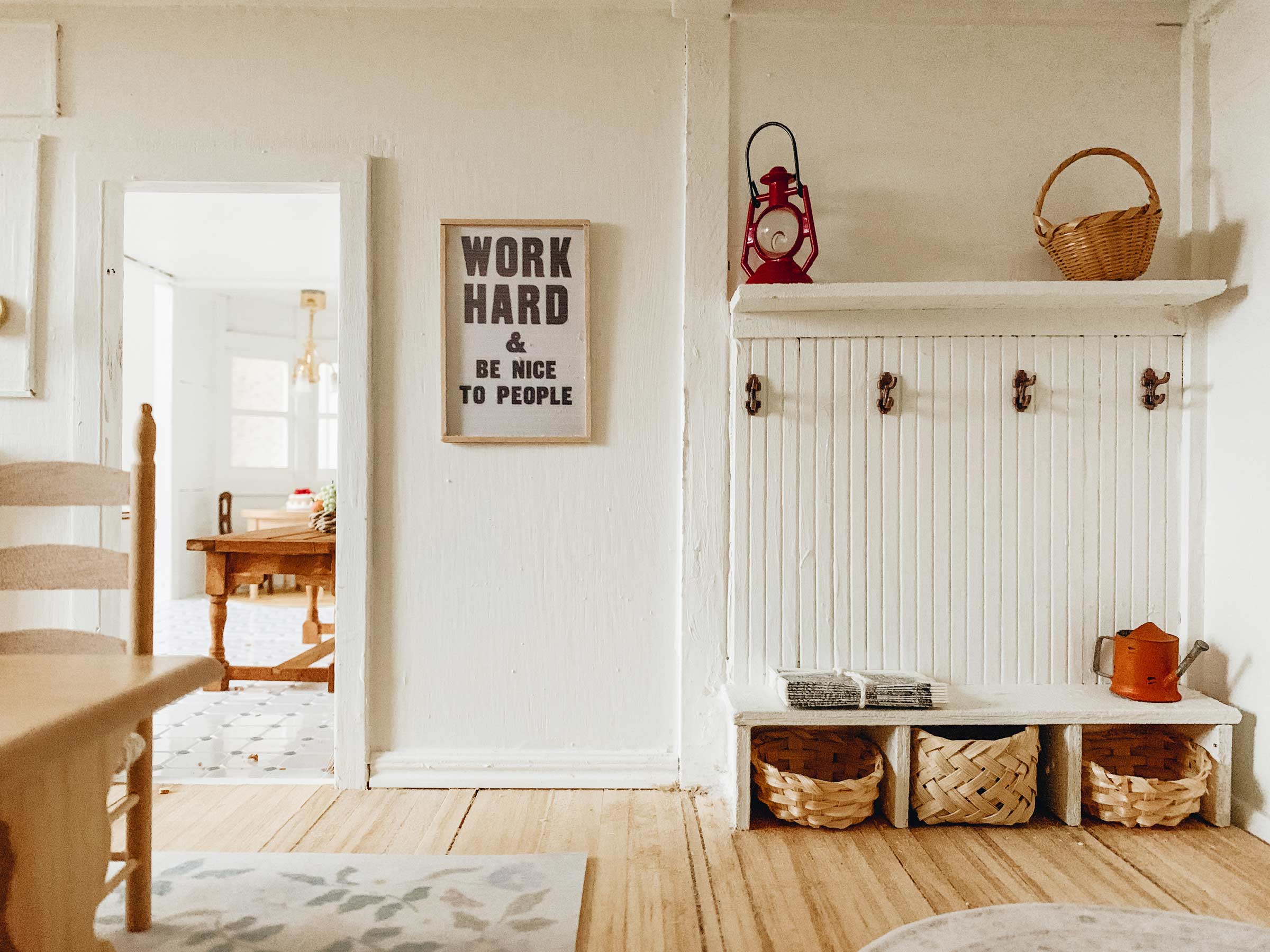 A Work Hard Print inside a dollhouse. 