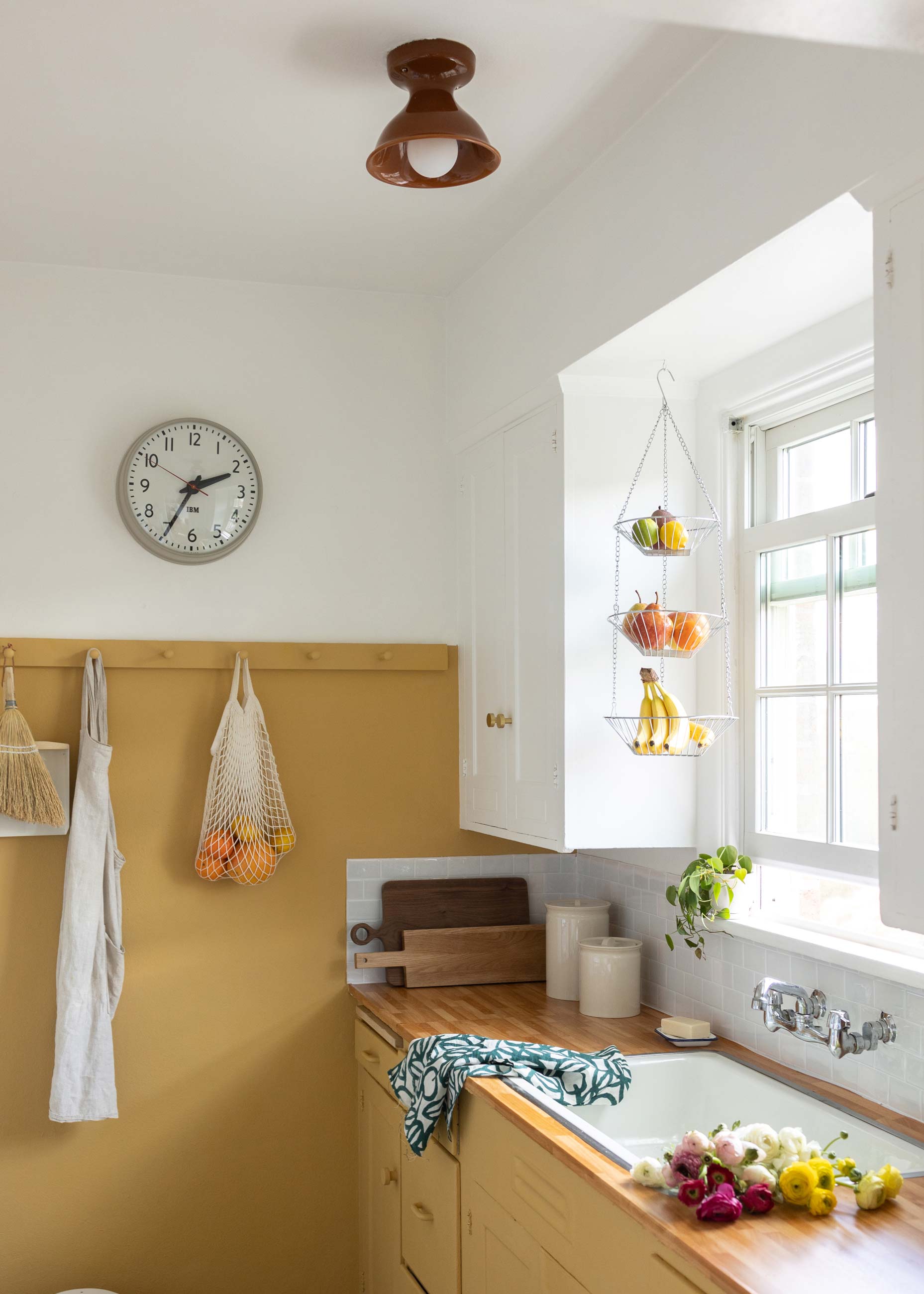 Sunny yellow kitchen with brown surface mount above sink. 