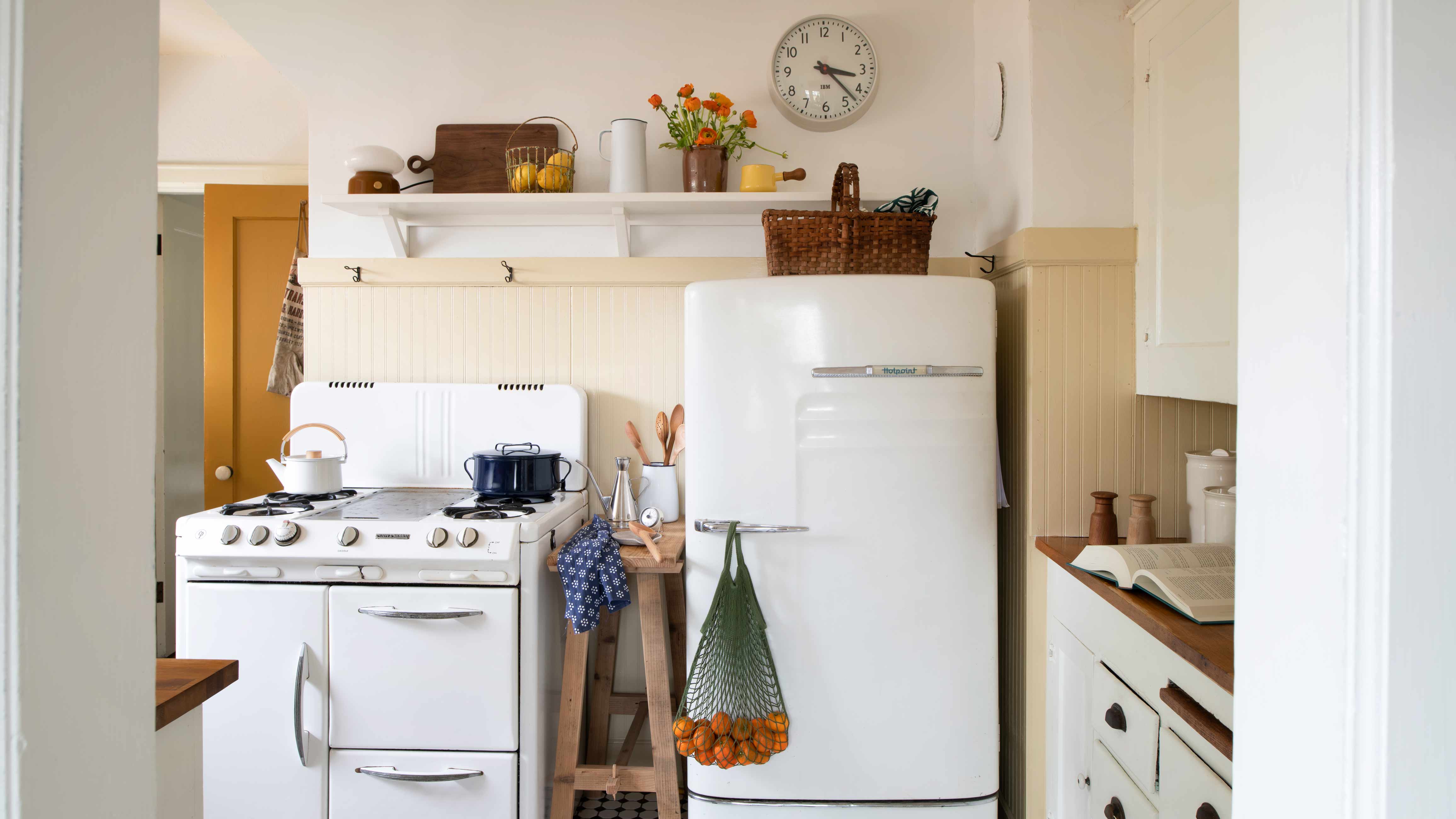 Kitchen with open shelving above fridge and stove.