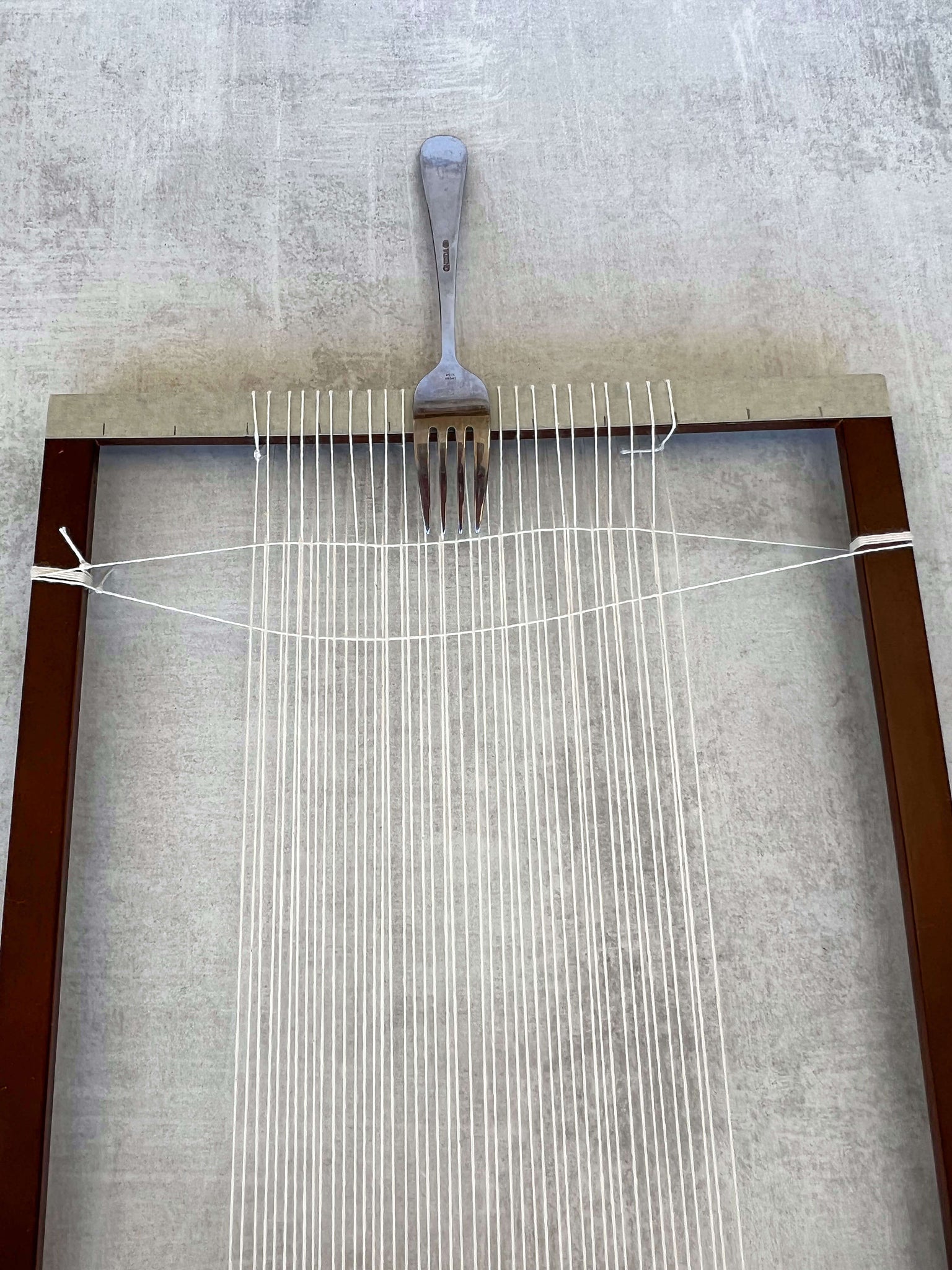 packing ordering threads to top of the looms with a fork