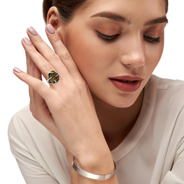 A woman's hand showcasing a 9 CT Pyrite Sterling Silver Tree Branch Ring, adding elegance to her overall look