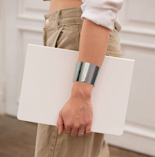 Woman holding white laptop wearing 1 3/4 Inch Wide Hammered Stainless Steel Cuff Bracelet