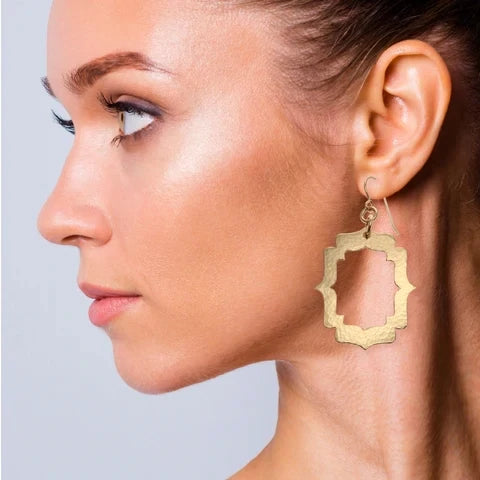 Female Model Wearing Pierced Hammered Bronze Arabesque Shield Earrings from John S. Brana