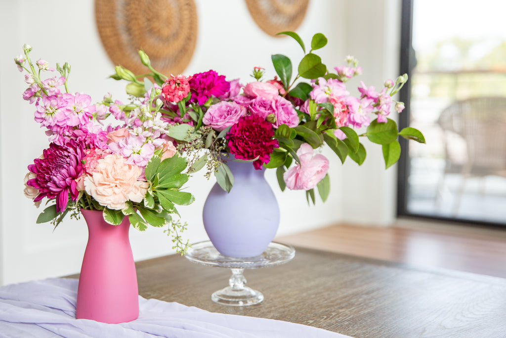 Fresh floral bouquets in colorful vases pulled from a cool storage unit.