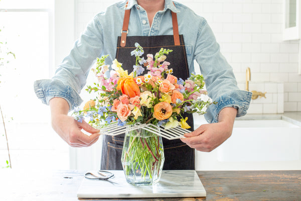 A florist demonstrates removing the DIY floral grid from a flower arrangement