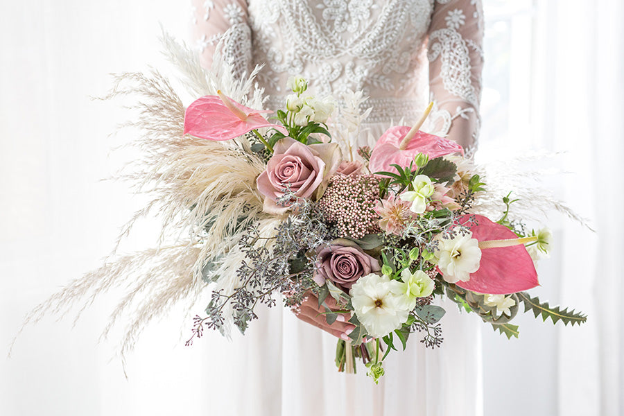 A bride posing with a floral bouquet