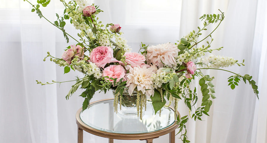 A pink and green flower arrangement in the Abby compote bowl