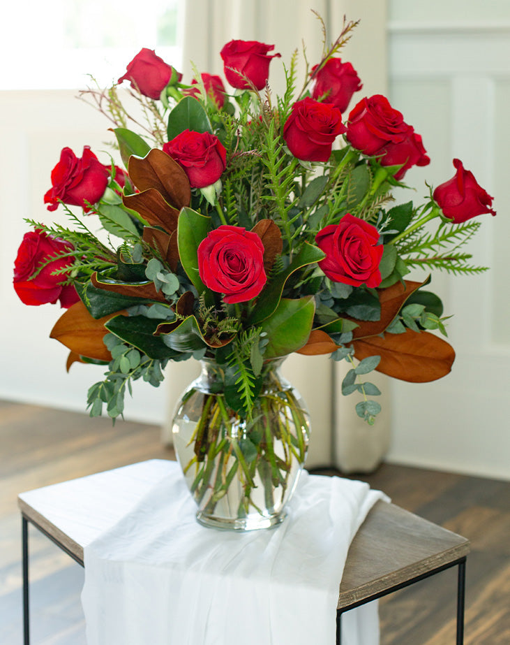 A bouquet of red roses arranged in a clear vase