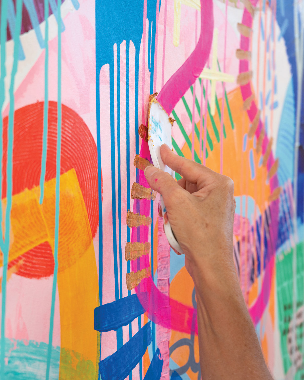 Close up of artist Tiff Manuell's hand painting small abstract details onto painting.