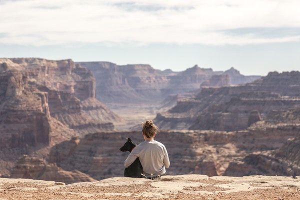 girl and dog hugging at view