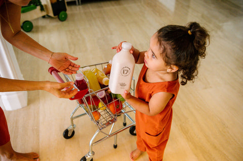 niña pequeña con romper terracota cargando leche vegana "mylk" de Life Blends