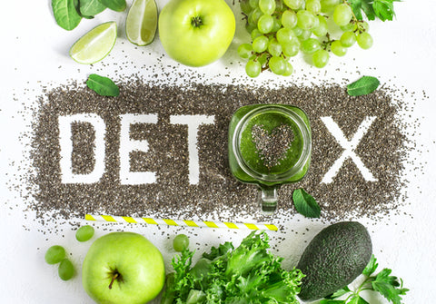 "detox" escrito sobre semillas de chia, rodeado de elementos verdes como manzana verde, col rizada, aguacate y uvas