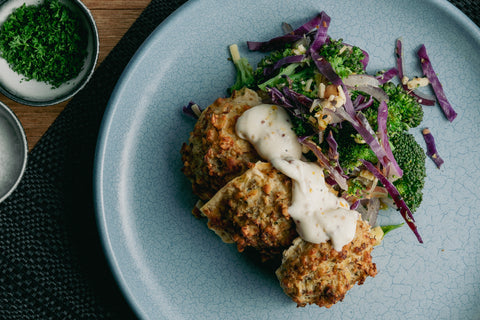 Cauliflower and halloumi fritters with broccoli salad on a table
