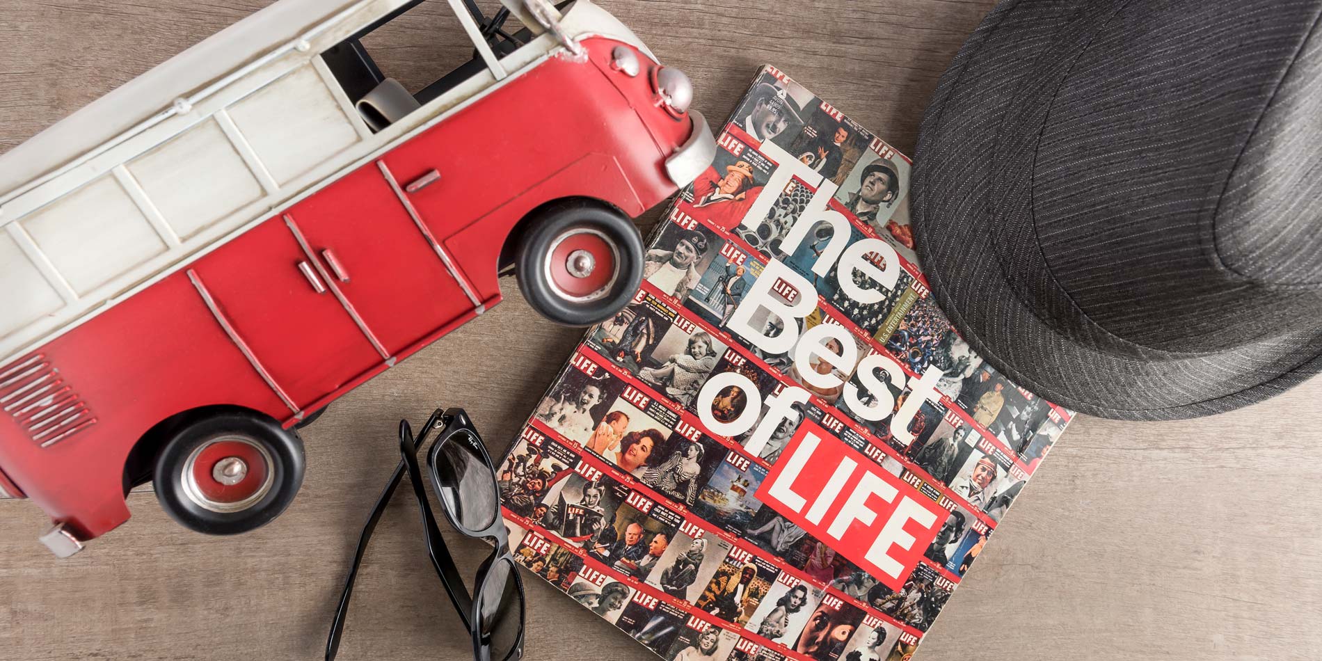 the best of life magazine, bus, hat, and sunglasses from the 50's on a table