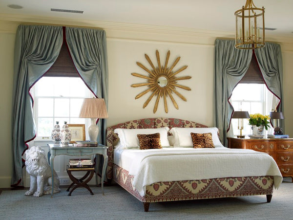 Sunburst mirror centered above a bed bedroom mirror ideas