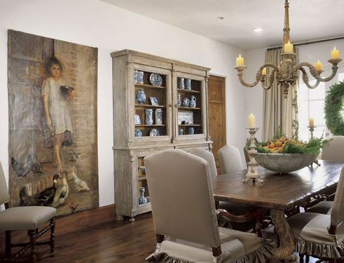 A lustre hangs above antique furnishings in this dining room. 