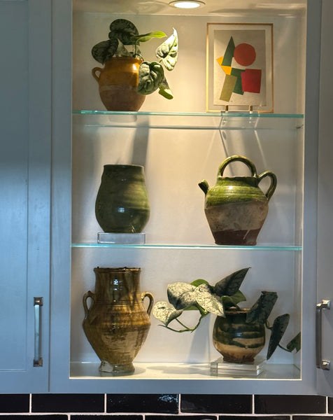 Antique French pottery collection on open shelves