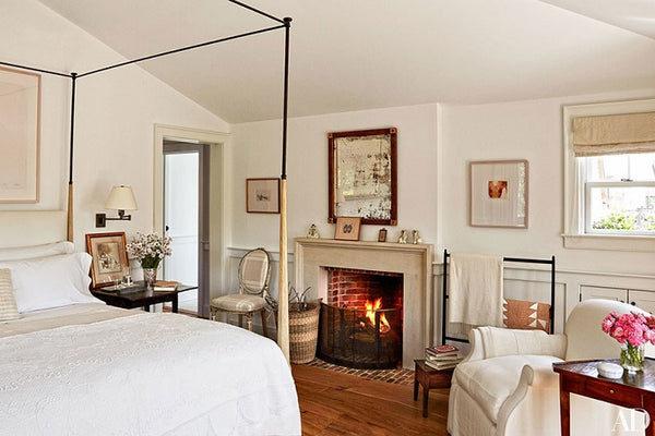 Antique mirror hanging above the fireplace in this Mark Cunningham designed bedroom