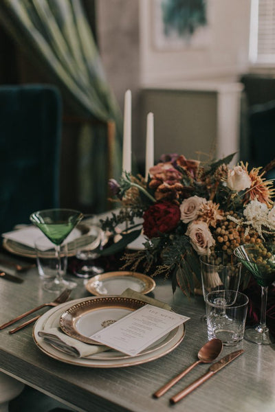 Elegant table setting with florals and green glasses