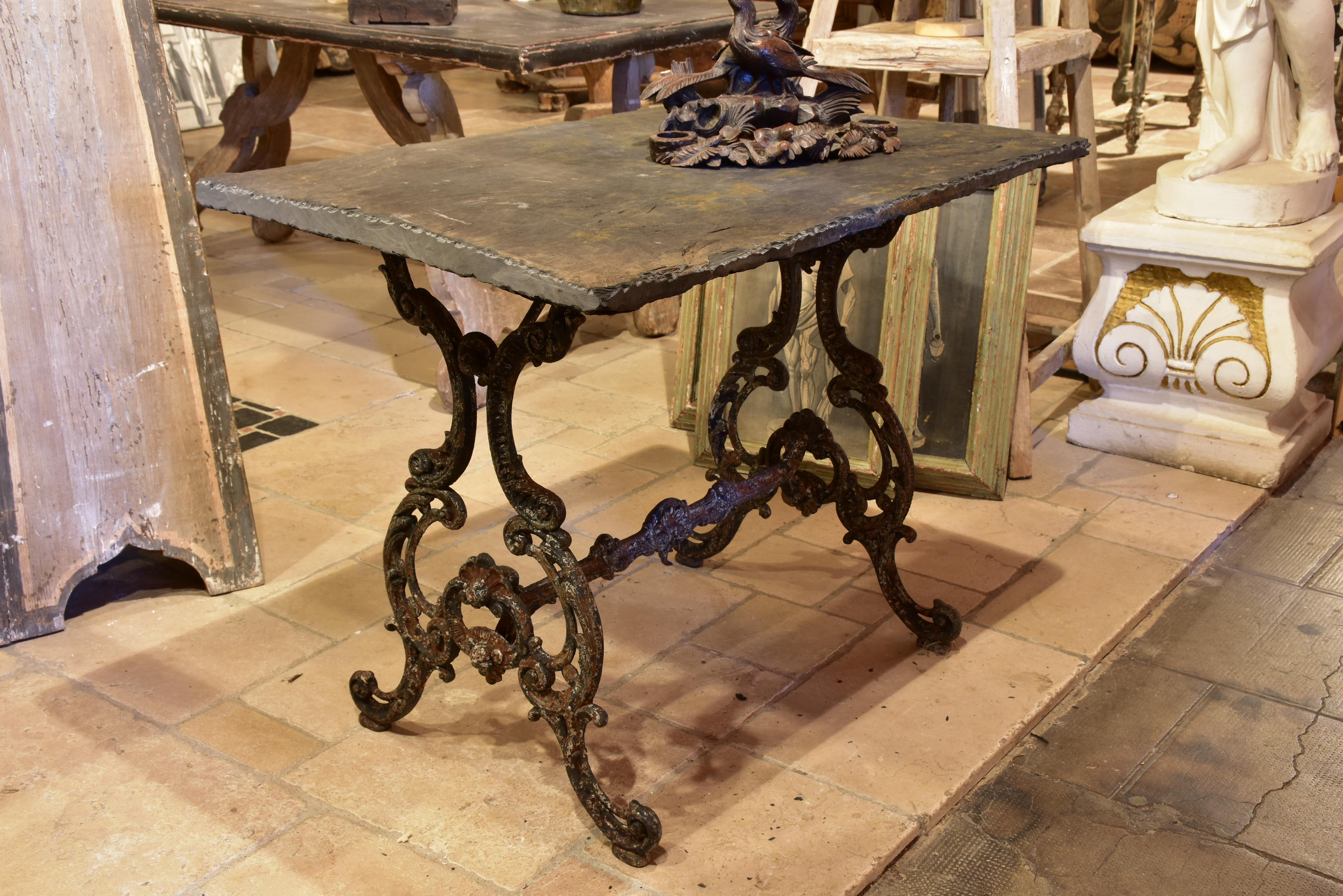 Antique French garden table with slate top and decorative cast iron ba