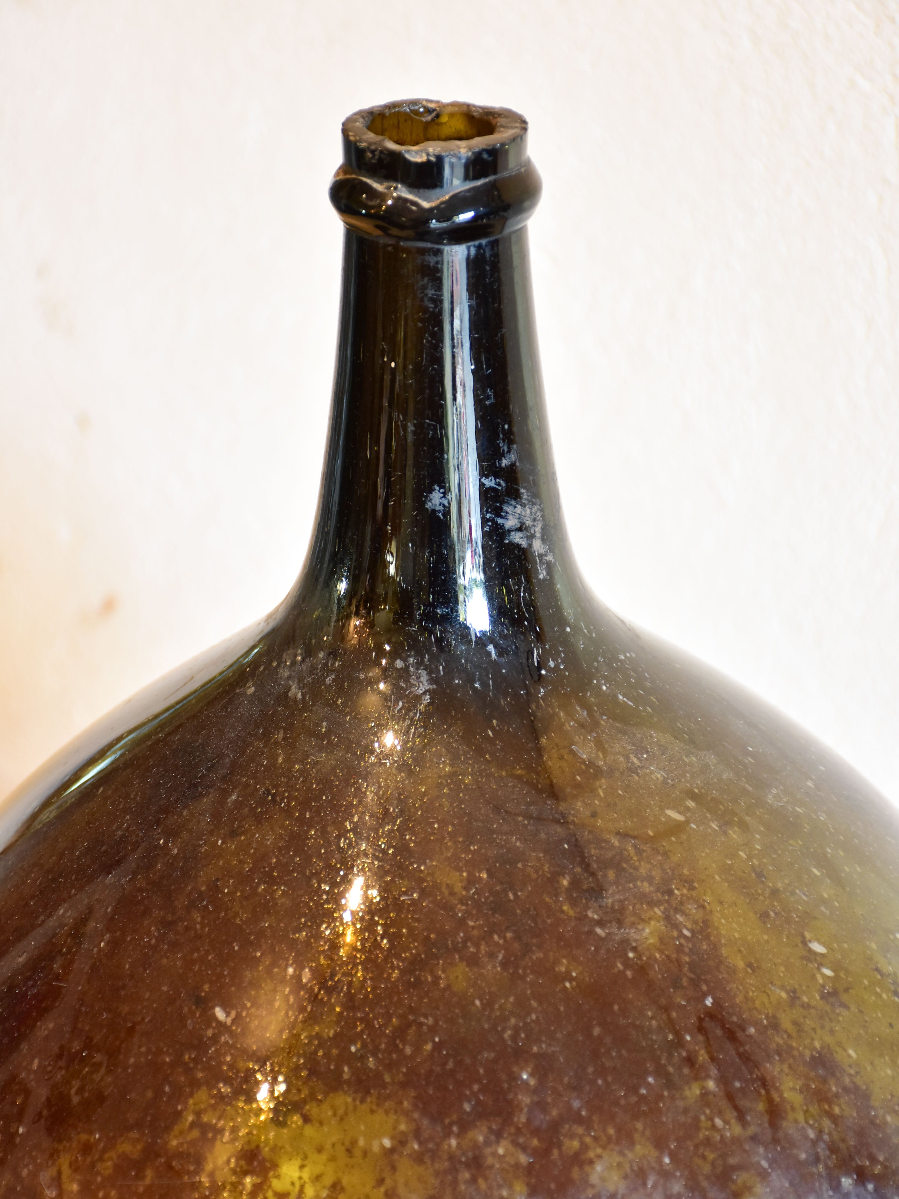 Antique demijohn bottle with dark Trinquetaille glass