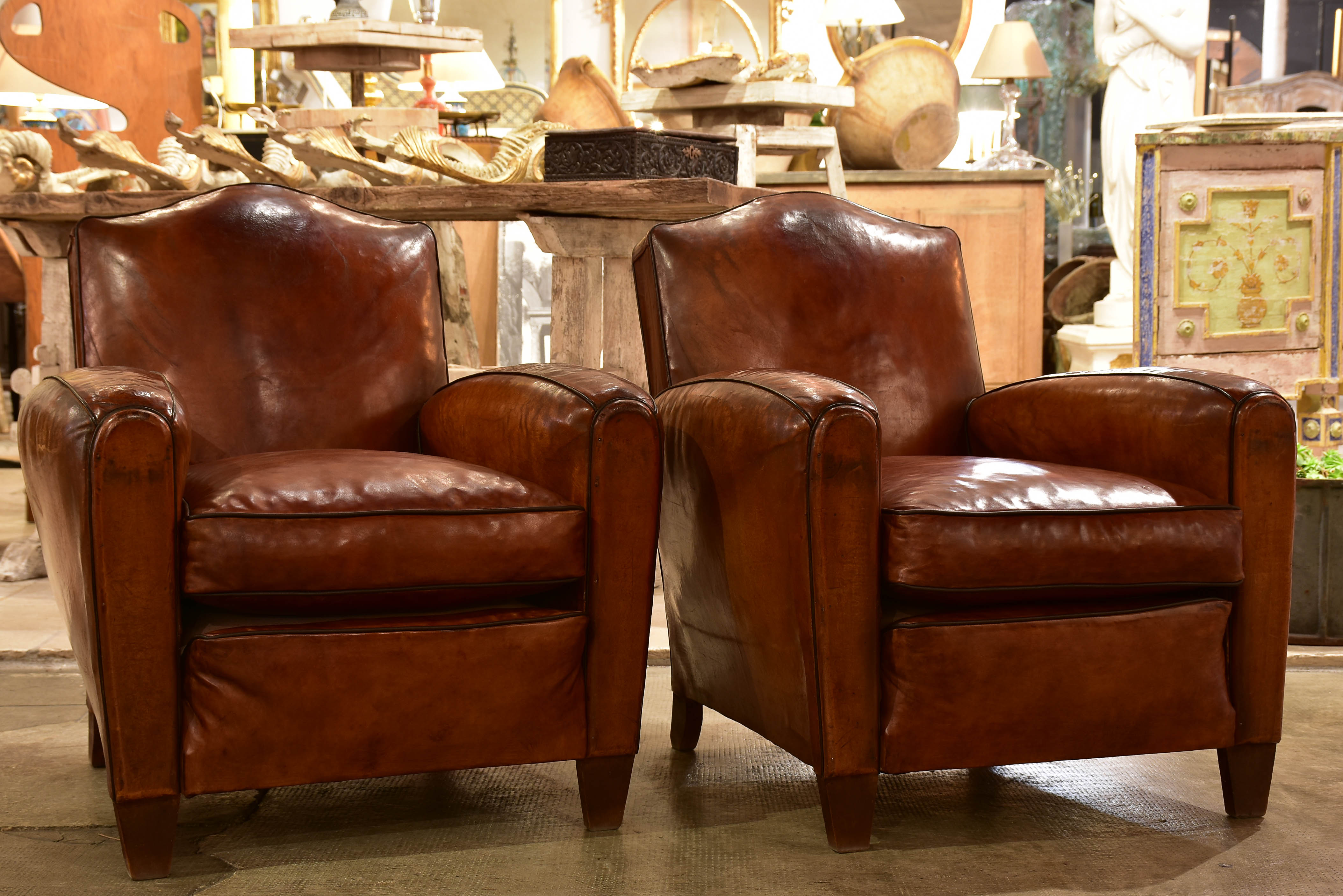 Pair of vintage French leather club chairs with chapeau gendarme