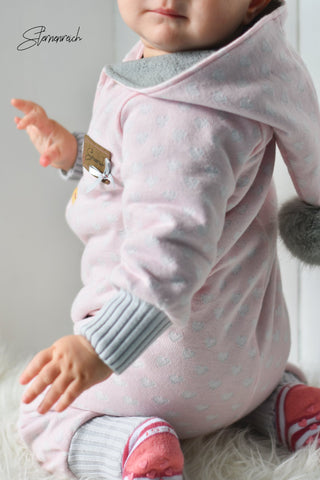 Jacquard-Strick-Jersey "Hearts", Grobstick-Bündchen "Knit", Mützenbommel/Bommel "Fur" genäht wurde ein Jumper/Jumpsuit von Klimperklein - Nähen für Babys/Kinder - Herbst/Winter - Glückpunkt.