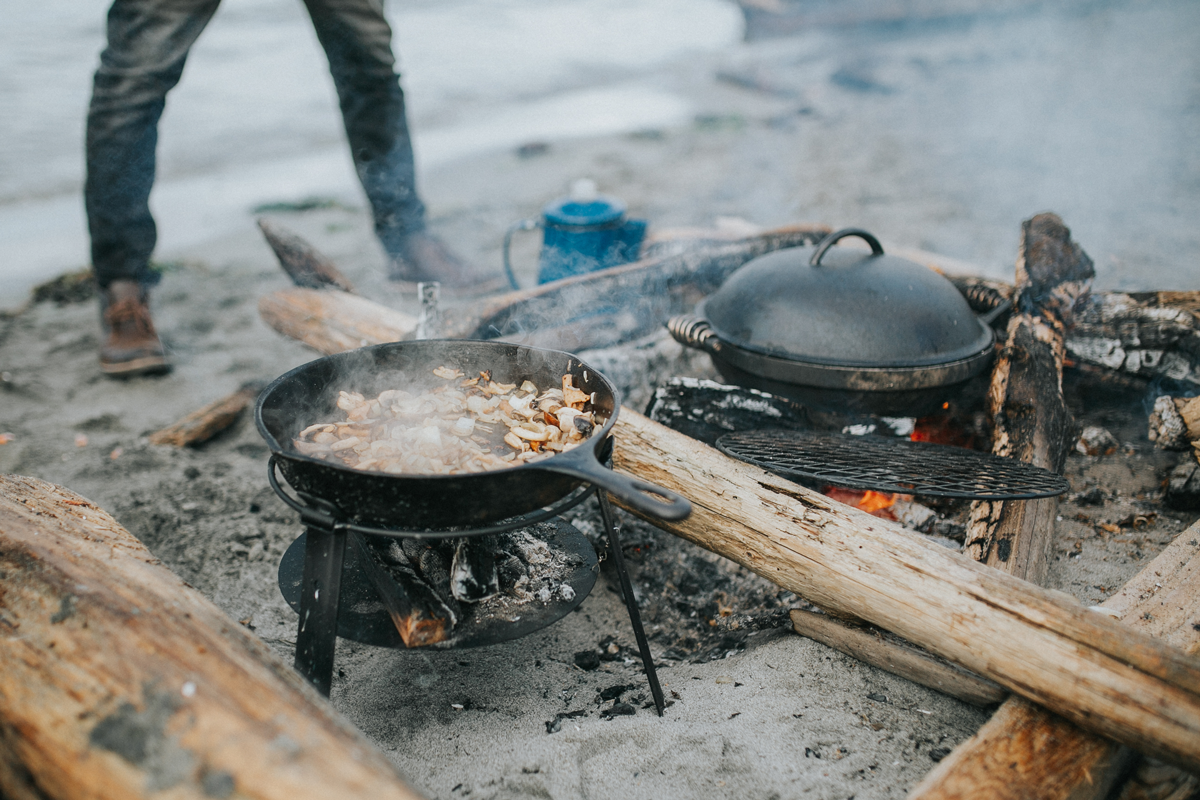 Beach fire with mushrooms sauteeing in cask iron barebones cooker