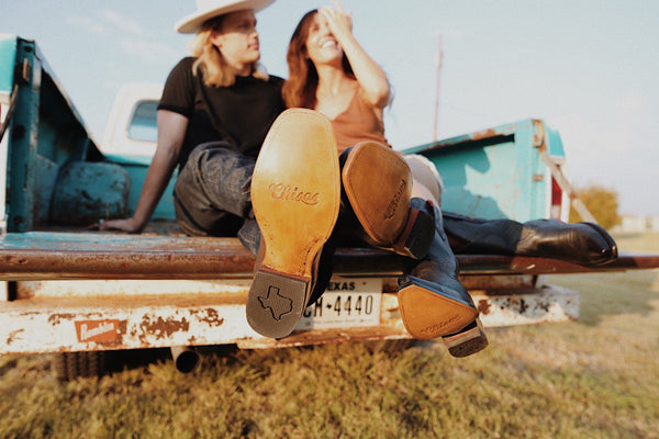 man and woman in truck bed with cowboy boots on