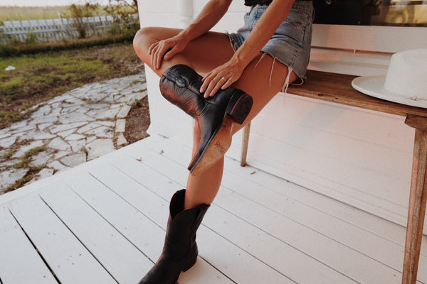 woman sitting on porch with cowboy boots
