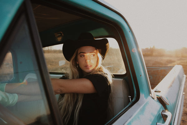 blonde woman driving old truck