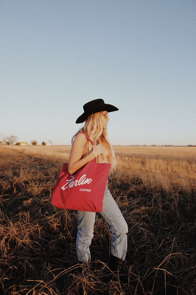 woman with red bag in field