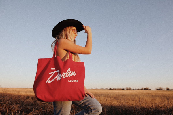 girl with red bag in field