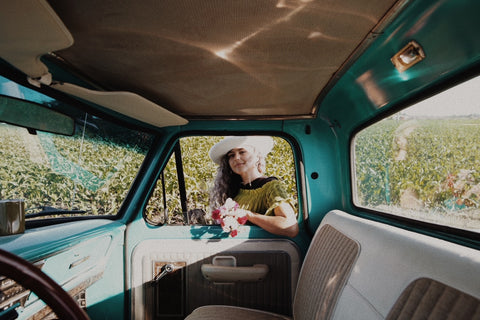girl in truck window with hat on
