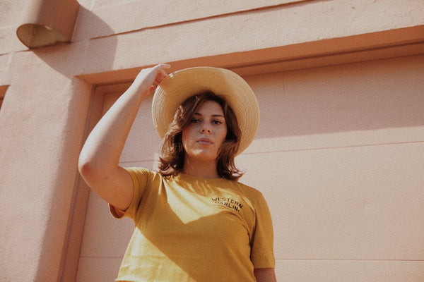 women in yellow tee with hat