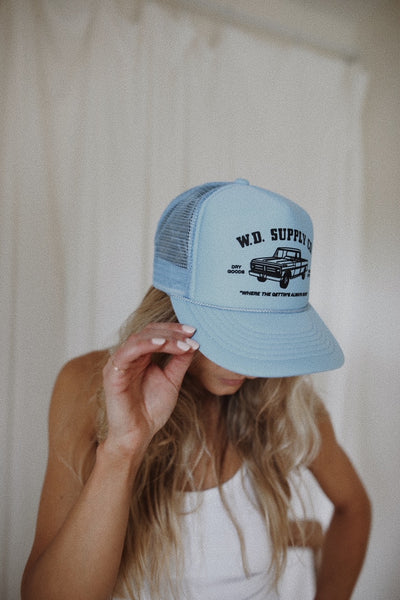 girl in blue trucker hat with truck