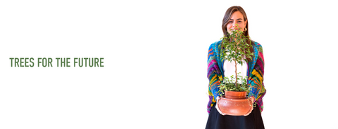 A friendly smiling girl wearing a colorful handknit sweater holding out a baby tree for you to see. The text next to this photo reads 'Trees for the Future'.