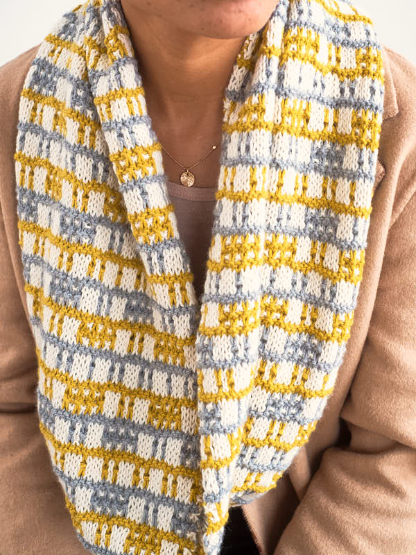 Kasiani, a modern eye-catching knit cowl shown in the colors #5801 Pearl, #5811 Golden, and #5806 Silver.