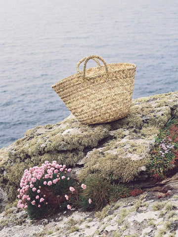 Bohemia Design Beldi Basket  sitting on a rock by the coast