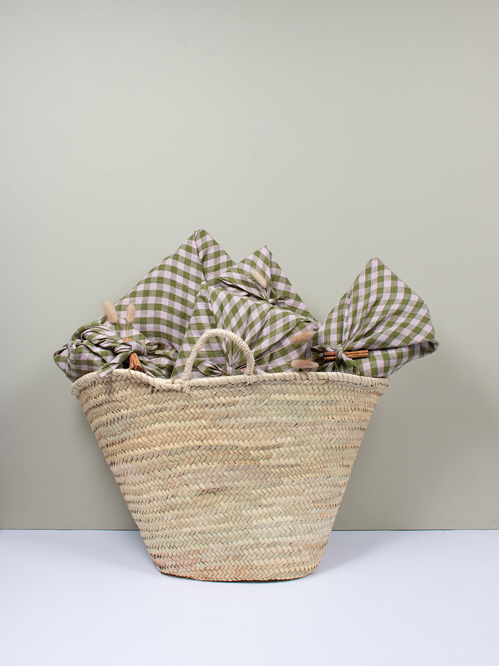 A Bohemia Design basket filled with wrapped christmas gifts