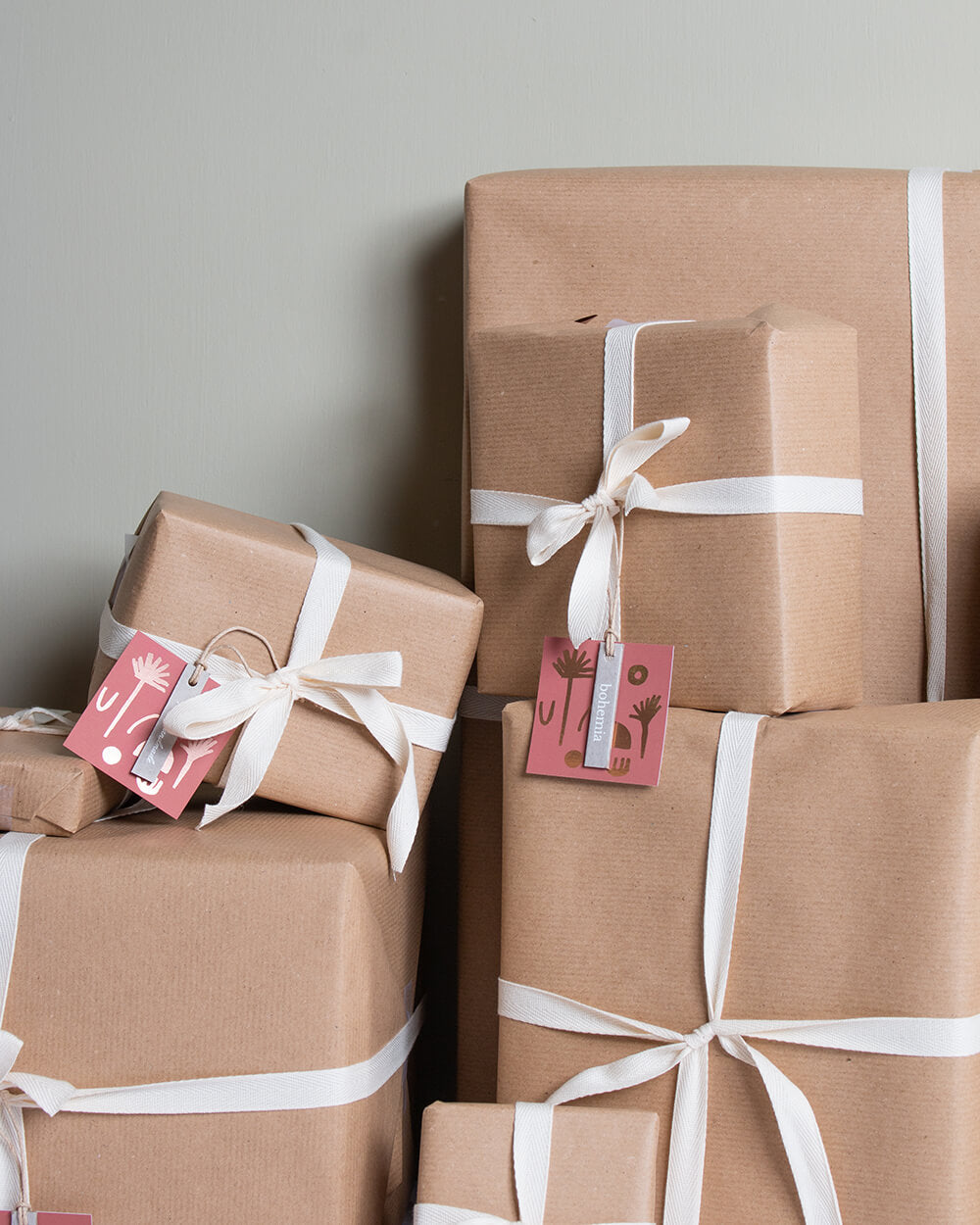 A pile of presents wrapped in brown paper with cream ribbon