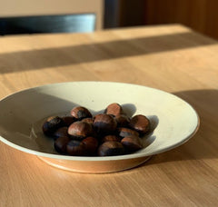 Chestnuts in white ceramic bowl on table