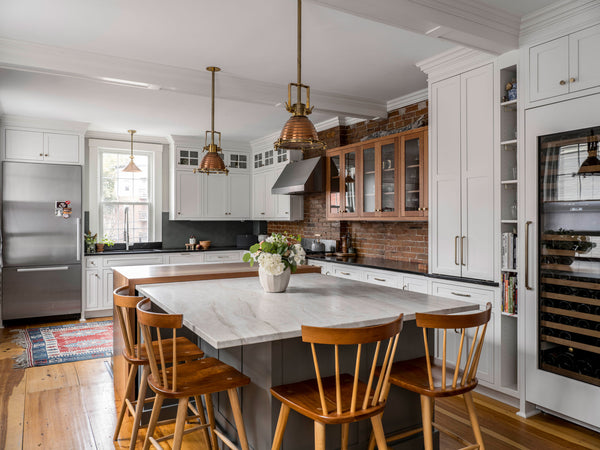 Renovated kitchen in Maine home with four counter stools around island