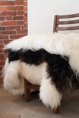 Stack of white and brown sheepskins on walnut dining chair