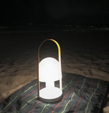 Portable lamp on blanket at beach at night